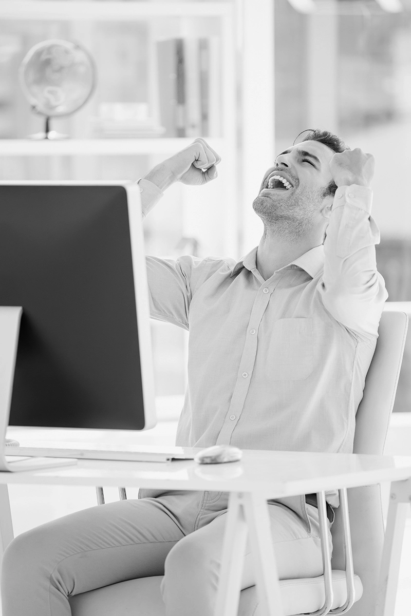 man cheering after he received help with his computer from huneidi services