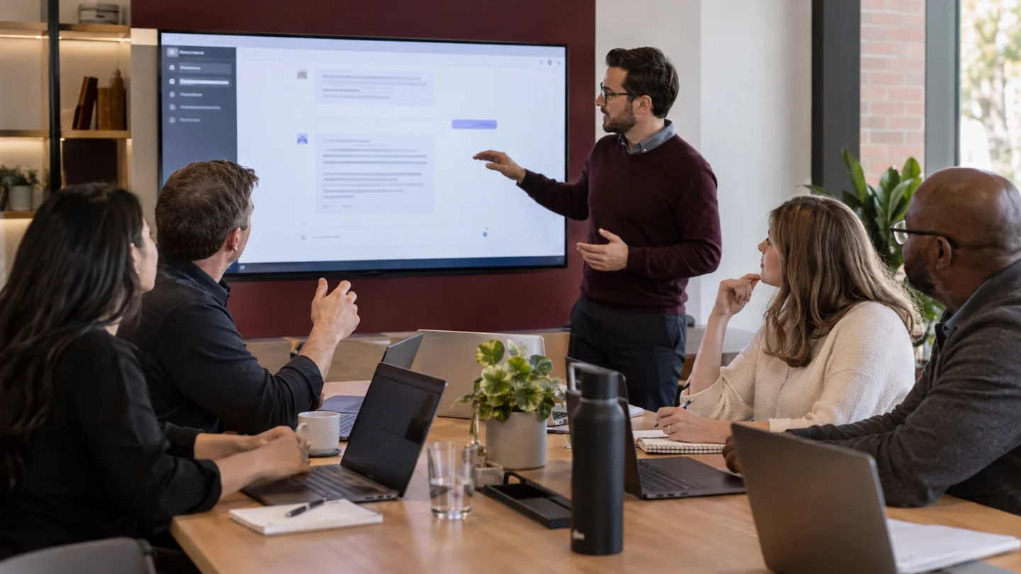 Team reviews presentation on large office display