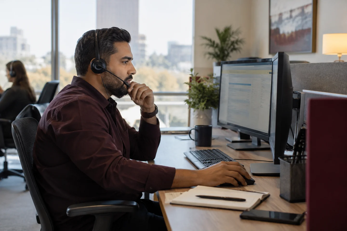 Customer service agent wearing headset works at office computer