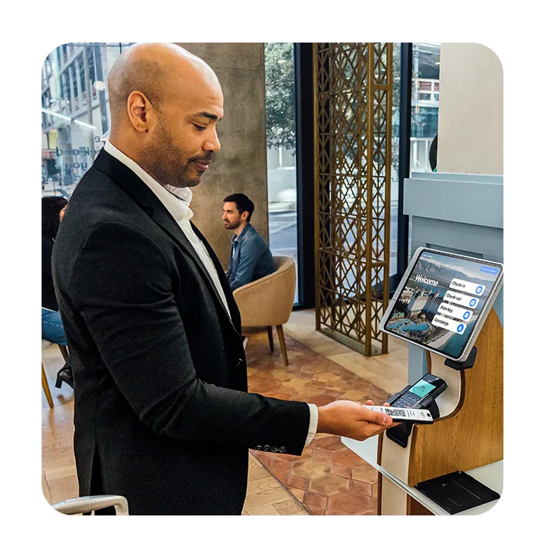 Man using self-service hotel check-in kiosk